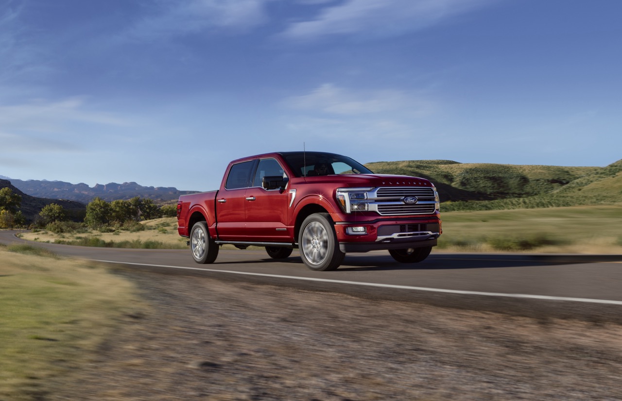 A red Ford F-150 driving on an open road